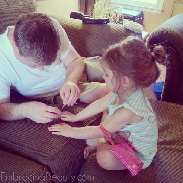 Daddy painting daughter's nails